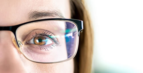 Woman with glasses showing reflection.
